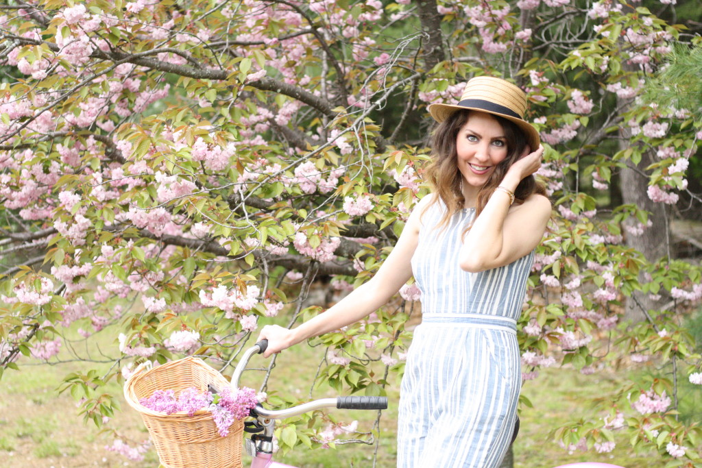 Blue and White Strip Jumpsuit with Boaters Hat with Jack Rogers Hampton Flip Flops on a Pink Cruiser Bike with fresh lilacs