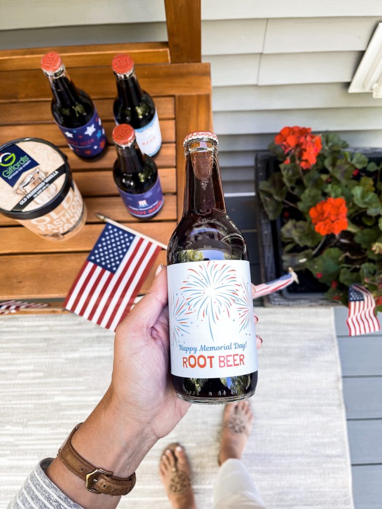 Holding a bottle of root beer with patriotic red white and blue label and American flag